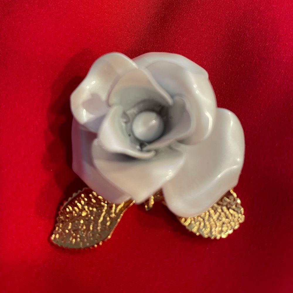 Giovanni white rose brooch with goldtone leaves, shown on the lapel of a top!